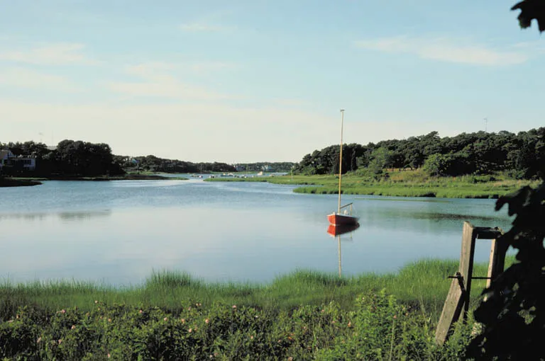 Quiet Cape Cod harbor with a sailboat and salt marsh